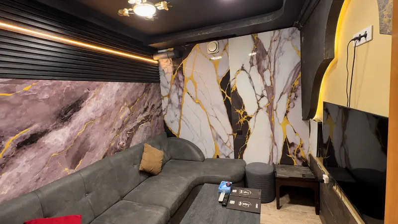 Room with white and gold marble walls and an L-shaped sofa